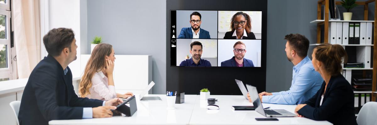 Group of co-workers on a video conference with remote co-workers